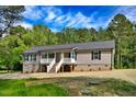 Charming single-story home with gray siding, stone foundation, and a welcoming front porch at 7122 Guess Rd, Hillsborough, NC 27278