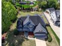 An aerial view of a blue house, showing its roof, landscaping, and surrounding neighborhood at 721 Shelley Rd, Raleigh, NC 27609