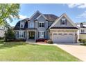 Charming two-story home with a well-manicured lawn, stone accents, and an attached two-car garage at 721 Shelley Rd, Raleigh, NC 27609