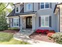 Beautiful home featuring a stone walkway, red flowers, and a stylish front door with decorative windows at 721 Shelley Rd, Raleigh, NC 27609