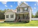 Classic two-story home featuring a cozy front porch with stone accents and hanging plants at 810 Mulberry Rd, Spring Hope, NC 27882