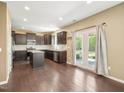 Modern kitchen featuring dark cabinets, stainless steel appliances, a central island, and patio access at 835 Poplar St, Durham, NC 27703