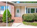 Inviting front entrance with brick steps, an oval window door, and well-maintained landscaping at 926 Allister Rd, Durham, NC 27703