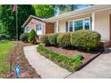 Well-kept front yard with lush greenery, sidewalk, and charming home exterior with brick and siding at 926 Allister Rd, Durham, NC 27703