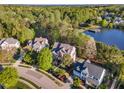 Stunning aerial view of an estate home in a wooded community near a lake at 944 Alden Bridge Dr, Cary, NC 27519