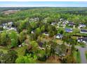 An aerial view showcasing the community with lush green trees, several rooftops, and neighborhood streets at 95 Torrington Ave, Franklinton, NC 27525