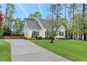 View of the charming home featuring a basketball court, long driveway, and well-maintained landscaping at 95 Torrington Ave, Franklinton, NC 27525