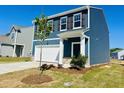 Charming two-story home with blue siding, a two-car garage, and a neatly landscaped front yard at 107 Gabriel Ct, Wilson's Mills, NC 27520