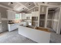 Modern kitchen features white cabinetry, a central island, abundant counter space, and is awaiting final finishes at 107 Tee Dr, Selma, NC 27576
