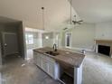 Kitchen island with granite countertop, sink, and open living space at 107 Tee Dr, Selma, NC 27576