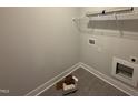 Functional laundry area with shelving, hookups, and stylish tile flooring, offering convenience and modern appeal at 107 Tee Dr, Selma, NC 27576