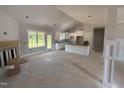 Open-concept living space with fireplace, adjacent to bright, white kitchen at 107 Tee Dr, Selma, NC 27576