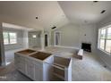 Spacious living room with fireplace and open kitchen with island, creating an inviting atmosphere at 107 Tee Dr, Selma, NC 27576