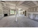 Spacious open-concept living room and kitchen featuring fireplace, abundant natural light, and modern design elements at 107 Tee Dr, Selma, NC 27576