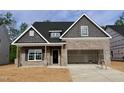 Charming single-Gathering home with brick and gray siding, two-car garage, and inviting front porch at 1075 Fairhaven Dr # 51, Mebane, NC 27302