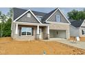 Newly constructed home features brick, shake accents, covered entrance, and two car attached garage at 1075 Fairhaven Dr # 51, Mebane, NC 27302