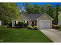 Charming single-story home featuring a well-maintained lawn, neat landscaping, and an attached one car garage at 108 Braxberry Way, Holly Springs, NC 27540