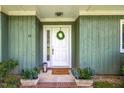 Inviting front door with a wreath and potted plants on a brick step at 12 Poppy Trl, Durham, NC 27713