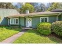 A charming one-story green house with manicured shrubs lining the walkway at 12 Poppy Trl, Durham, NC 27713