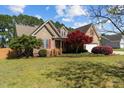 Beautiful home with lush landscaping, mature trees, and a well-maintained lawn at 140 Adams Pointe Ct Ct, Angier, NC 27501