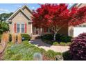 Charming front entrance with stone walkway, vibrant landscaping, and a beautiful red tree at 140 Adams Pointe Ct Ct, Angier, NC 27501