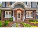 Inviting front porch with brick columns, white chairs, and colorful landscaping at 1403 Vickers Ave, Durham, NC 27707