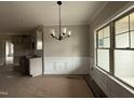 Dining area featuring a modern chandelier, wainscoting and large window for natural light at 152 Royal Ave, Selma, NC 27576