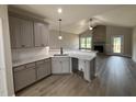 Modern kitchen with gray cabinetry, granite countertops, a breakfast bar, and stainless steel appliances at 152 Royal Ave, Selma, NC 27576
