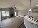 Open-concept living room featuring a vaulted ceiling, fireplace, and access to a deck at 152 Royal Ave, Selma, NC 27576