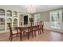 Formal dining room with elegant chandelier, large windows, and built-in display cabinet at 1602 Lake Shore Dr, Dunn, NC 28334