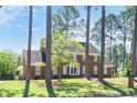 Two-story brick home with mature landscaping, stately trees, and an inviting front entrance at 1602 Lake Shore Dr, Dunn, NC 28334