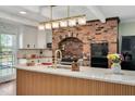 Modern kitchen with brick oven feature, white cabinets, a large island, and contemporary lighting at 1602 Lake Shore Dr, Dunn, NC 28334