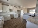 Spacious kitchen featuring white cabinets, granite countertops, and stainless steel sink at 172 Royal Ave, Selma, NC 27576