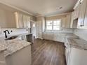 Well-lit kitchen with white cabinets, granite countertops, and hardwood flooring at 172 Royal Ave, Selma, NC 27576