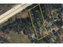 Aerial view of parcels including a house on a lot with trees. Near to the road with industrial or commercial business nearby at 1823 E Geer St, Durham, NC 27704