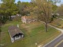 Estate including a stone cottage, an additional small home, tall trees, and gravel driveway at 1823 E Geer St, Durham, NC 27704