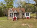 Charming stone cottage with a red-brick chimney and matching stairs leading to a covered front porch entrance at 1823 E Geer St, Durham, NC 27704