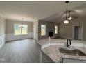 Beautiful kitchen featuring stone countertops, stainless faucet, and view to living room at 192 Royal Ave, Selma, NC 27576