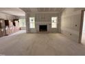Unfinished living room with a fireplace, large windows, and exposed drywall at 192 Royal Ave, Selma, NC 27576