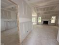 Spacious living room with fireplace, large windows, and unfinished drywall at 192 Royal Ave, Selma, NC 27576