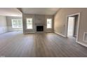 Spacious living room with large windows, a fireplace, and light wood flooring at 192 Royal Ave, Selma, NC 27576