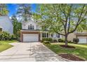 Inviting two-story home with a well-manicured lawn and brick-accented garage at 2002 Patapsco Dr, Apex, NC 27523