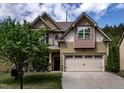 Inviting two-story home with neutral siding, attached garage, and mature tree in the front yard at 2012 Longmont Dr, Wake Forest, NC 27587
