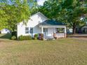 Quaint white home featuring a covered front porch and well-manicured lawn at 206 Mansfield Dr, Broadway, NC 27505
