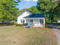 White home with covered porch and a well-maintained front lawn at 206 Mansfield Dr, Broadway, NC 27505