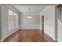 Elegant dining room with hardwood floors, large window, chandelier, and staircase views at 211 Kurtner Ct, Morrisville, NC 27560