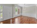 Formal dining room featuring hardwood floors, wainscoting, and an elegant chandelier at 211 Kurtner Ct, Morrisville, NC 27560