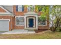 Inviting front entryway featuring a blue front door, detailed trim, and well-maintained landscaping at 211 Kurtner Ct, Morrisville, NC 27560