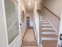Bright hallway featuring hardwood floors, white wainscoting and a staircase with wood and white accents at 221 Pond View Ct # 9, Fuquay Varina, NC 27526