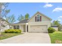 Inviting home with an attached two-car garage, landscaped yard, and covered porch, perfect for a starter home at 223 Triumph Dr, Elon, NC 27244